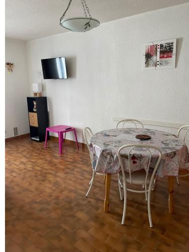 une salle à manger avec une table et une table et des chaises roses dans l'établissement Les logis de Magali les Zodiacs, terrasse, plage à 600m, à Argelès-sur-Mer