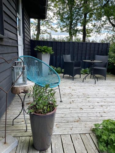 a patio with a blue bench and a table and chairs at Aneks i rolige omgivelser-adgang til pool og sauna in Avlum