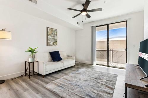ein Wohnzimmer mit einer Couch und einem Deckenventilator in der Unterkunft Glendale CozySuites - Westgate with pool 10 in Glendale