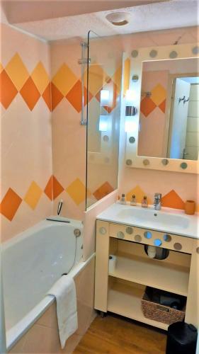 une salle de bain avec une baignoire, un lavabo et un miroir dans l'établissement Beachfront 4 people 2 swimming pool, à Cannes