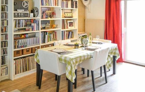 - une table à manger avec des chaises blanches et une étagère dans l'établissement Echoppe Bordelaise typique dans Bordeaux, à Bordeaux