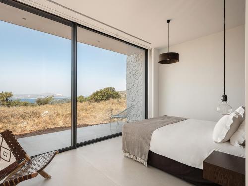a bedroom with a bed and a large window at Nature & Beauty Villa in Xirostérnion