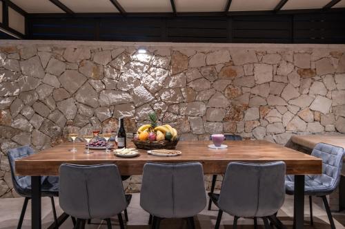 a wooden table with a basket of fruit and wine glasses at Artemis Villa in Lithakia