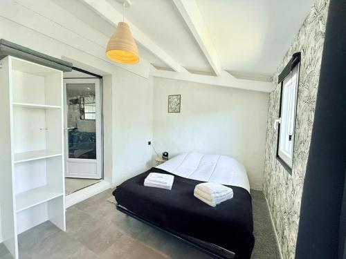 une petite chambre avec un lit et une fenêtre dans l'établissement 1753-3 L'atelier secret, à Échillais