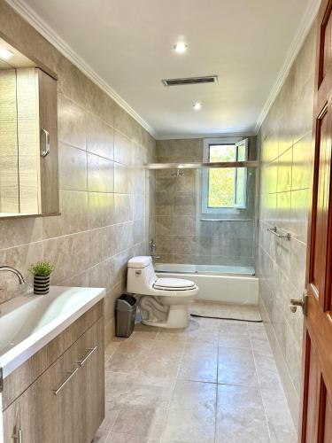 a bathroom with a toilet and a sink and a tub at Perl's Apartment in Póndi