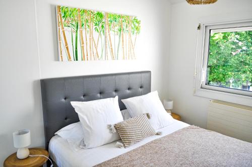 une chambre avec un lit avec des oreillers blancs et une fenêtre dans l'établissement La Villa du Brittany, à La Baule