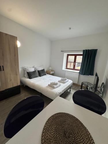 - un salon avec un lit et deux chaises dans l'établissement La République BY PRIMO C0NCIERGERIE, à Tournus