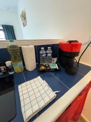 un comptoir bleu avec des bouteilles d'eau et des serviettes en papier dans l'établissement La République BY PRIMO C0NCIERGERIE, à Tournus