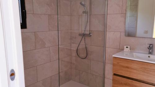 d'une douche avec un pommeau à côté d'un lavabo. dans l'établissement Domaine de Gialla Bergerie I Pini, 8 pers, piscine chauffée, 10 mn plage, à Arraggio