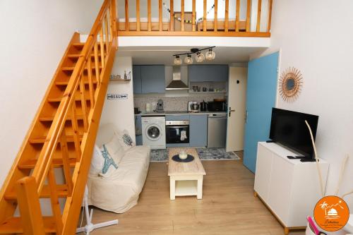 un salon avec un canapé et un escalier dans l'établissement St Cyprien Plage jolie maison proche plage, à Saint Cyprien Plage