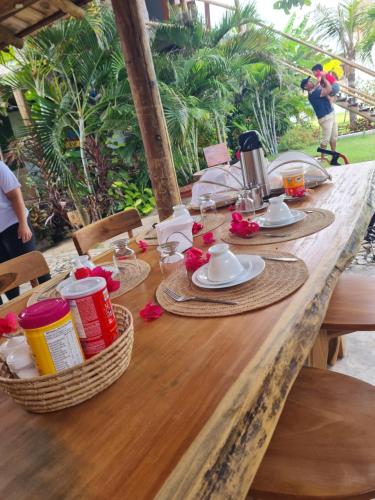a wooden table with plates and utensils on it at Chalés Refúgio Fortim in Fortim