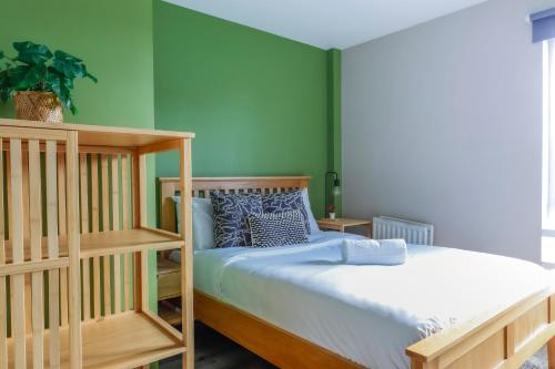 1 dormitorio con paredes verdes y 1 litera en Noah Suite - Central 2BR Apartment with Parking & WIFI, en Cardiff