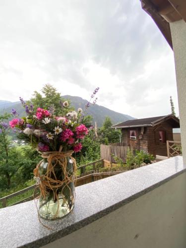 a vase filled with flowers sitting on a ledge at Chalet Mühlbachl In Rohrberg Rohr in Zell am Ziller
