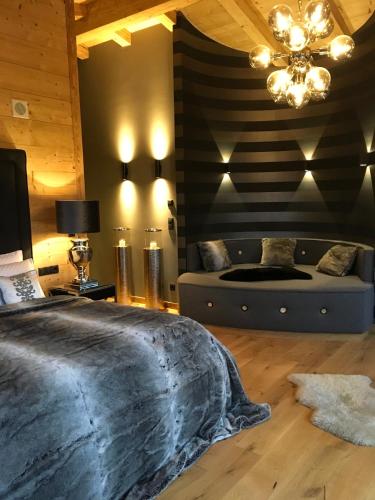 a bedroom with a large bed and a couch at Chalet Tannweg In Sankt Johann In Tirol in Alpendorf