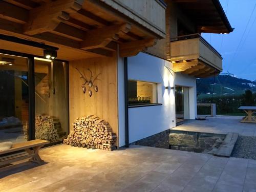 a house with a fireplace in the backyard at Chalet Tannweg In Sankt Johann In Tirol in Alpendorf
