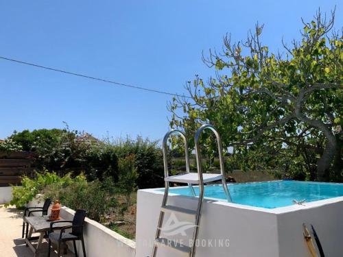 - une piscine avec une table et des chaises dans l'arrière-cour dans l'établissement Countryhome Pomar, à Odeceixe