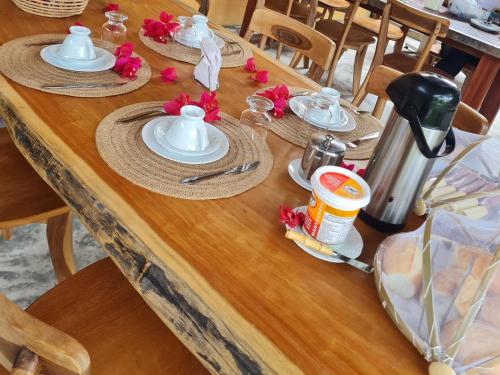 a wooden table with plates of food on it at Chalés Refúgio Fortim in Fortim