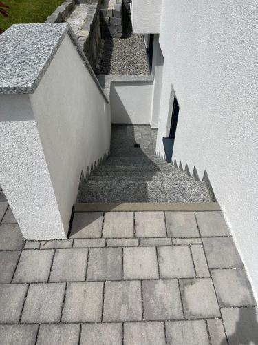 a stairway leading up to a white building at Ferienwohnung In Ruhiger Lage In Seenähe in Oberteuringen