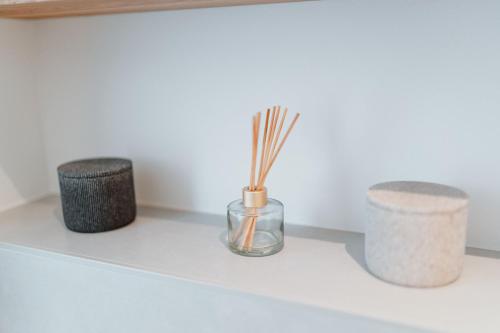 three vases on a shelf with sticks in them at Spreewaldhaus Am Landgut Der Stall in Markische Heide