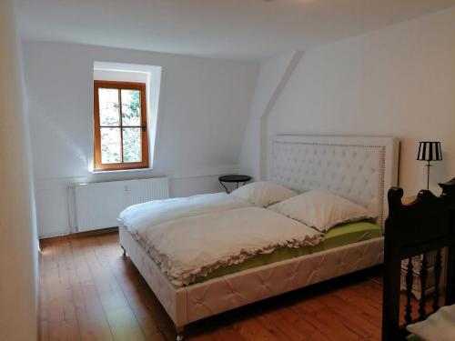 Un dormitorio con una cama grande con ventana. en Bergblick, en Königstein