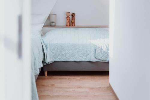 a bedroom with a bed with a blue comforter at Spreewaldhaus Am Landgut Der Stall in Markische Heide