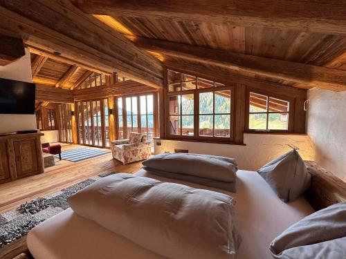 a bedroom with two beds in a room with wooden ceilings at Panoramasuite in Flattach