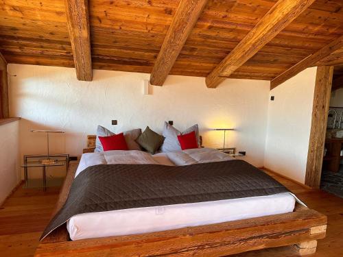 a large bed in a room with wooden ceilings at Panoramasuite in Flattach