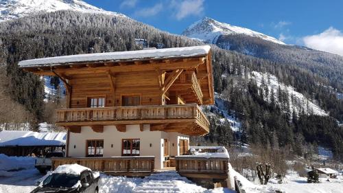 a log cabin in the snow with a mountain at Panoramasuite in Flattach