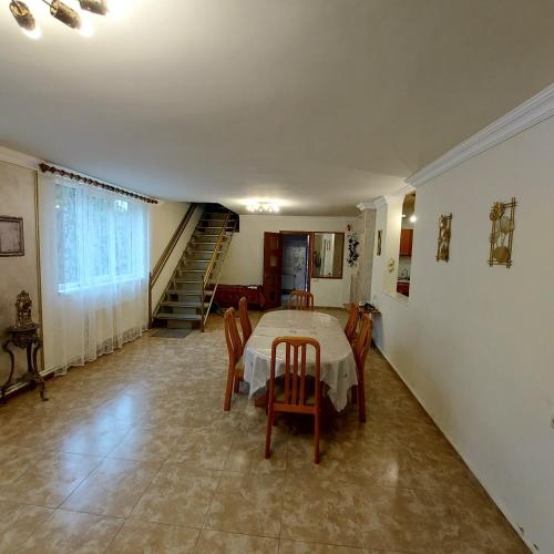 a dining room with a table and chairs and a staircase at Komfort in Aghk'ilisa