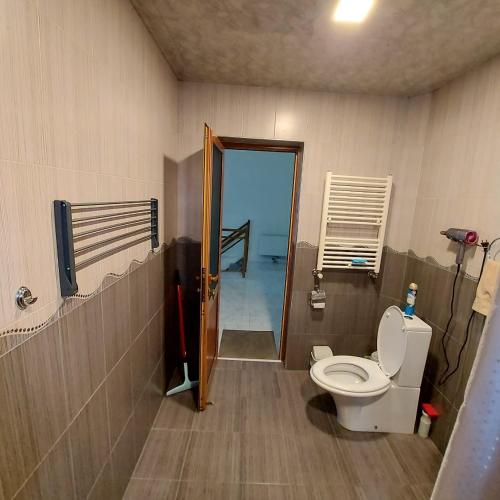 a bathroom with a toilet and a door with a balcony at Komfort in Aghk'ilisa