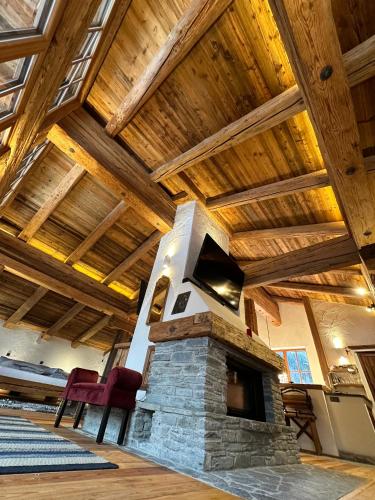 a fireplace in a room with a wooden ceiling at Panoramasuite in Flattach