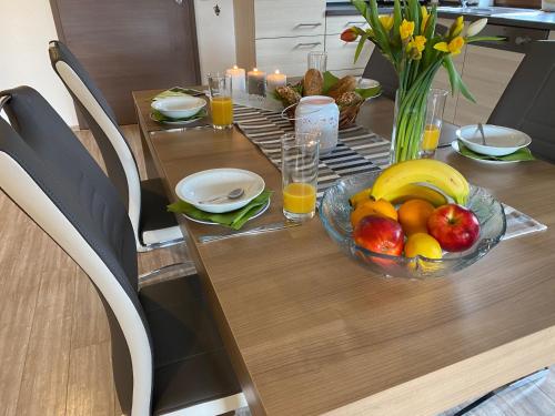 a wooden table with a bowl of fruit on it at Gästehaus Siebert in Bad Brambach