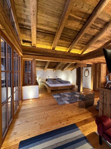 a large room with a bed on a wooden ceiling at Panoramasuite in Flattach