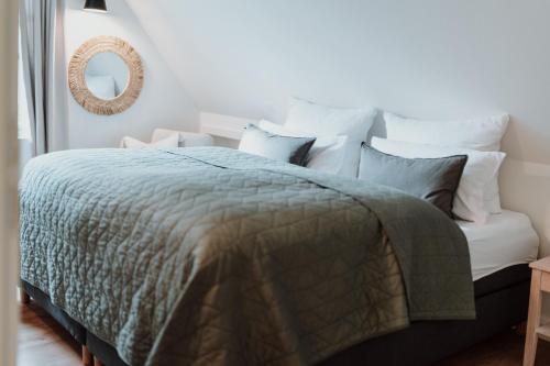 a bedroom with a bed with a green comforter and pillows at Spreewaldhaus Am Landgut Das Haupthaus in Markische Heide