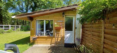 une petite cabane en bois avec une porte en verre dans l'établissement cabane, à Saint-Vincent-de-Paul