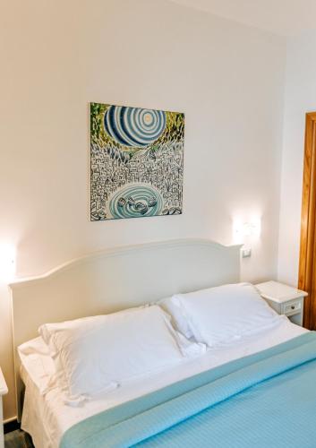 a bed in a bedroom with a painting on the wall at Hotel Cava Dell'Isola in Ischia