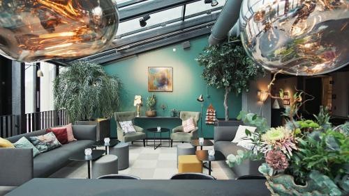 a lobby with couches and plants in a room at Quality Hotel Winn Haninge in Haninge