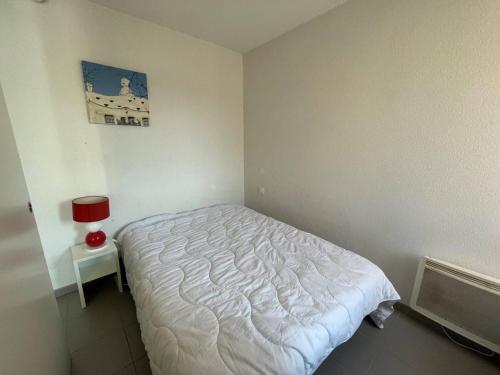 une chambre avec un lit blanc dans une pièce dans l'établissement Argelès sur mer - Appartement deux pièces - AR920-006, à Argelès-sur-Mer