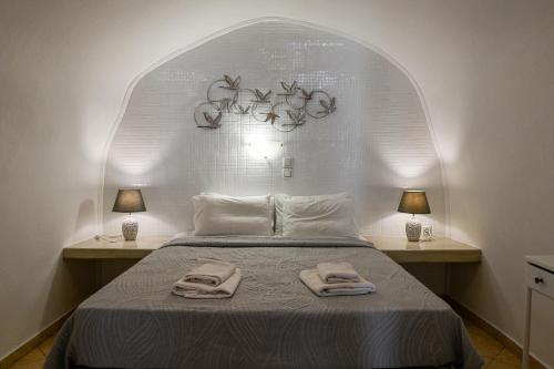 a bedroom with a bed with two towels on it at Vinas Place City Center in Fira