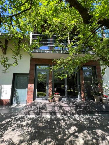 a brick building with a tree in front of it at Tulipan Hotel Aquapark in Vyshkove