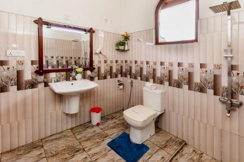 a bathroom with a toilet and a sink at Ella Heaven Inn in Kumbalwela