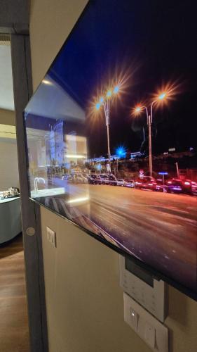 a television with a picture of a city at night at Alba Suites in Vlorë