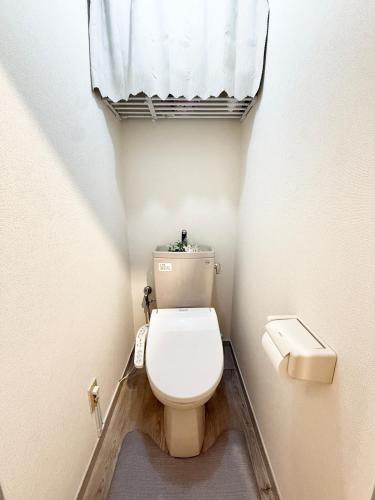 a small bathroom with a toilet and a window at MIKASA guesthouse2 in Tokyo