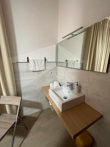 a white bathroom with a sink and a mirror at B&B IMMARE in Brindisi