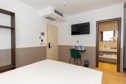 a bedroom with a large white bed and a chair at Lh HOTELS in Milan