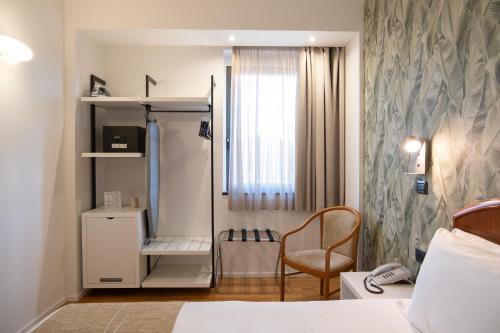 a bedroom with a bed and a chair and a window at Hotel Dei Congressi in Rome