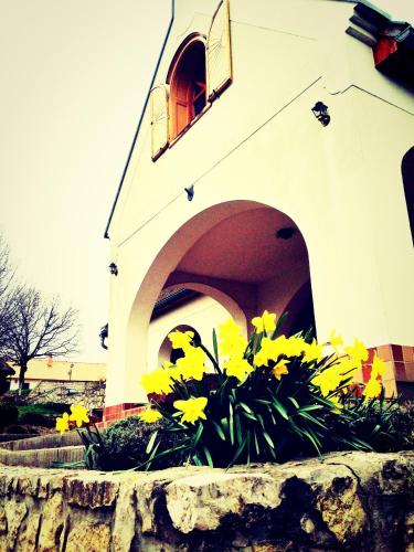 a church with yellow flowers in front of a building at Figula Vendégház in Balatonfüred