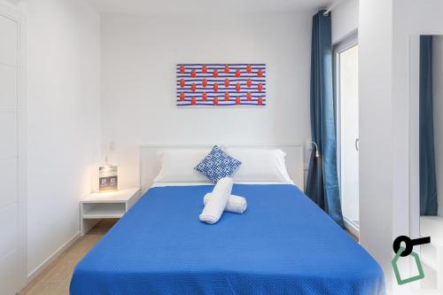 a bedroom with a blue bed with a blue blanket at HOTIDAY Room Collection - Byò Home in Sorrento