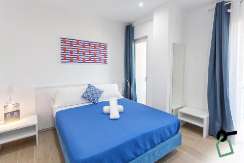 a bedroom with a blue bed with a teddy bear on it at HOTIDAY Room Collection - Byò Home in Sorrento
