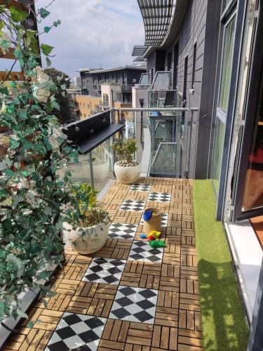 a balcony with a checkered floor and plants at Unique Penthouse with Home Cinema, Panoramic Views & Eco-Chic Design in London
